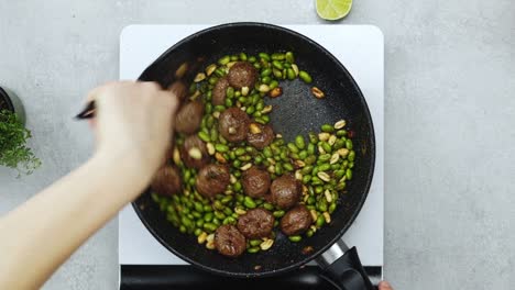 mujer cocinando frijoles verdes y albóndigas