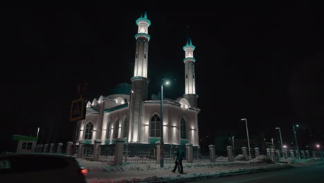 magnífica mezquita con minaretes y cúpula en la calle de la noche nevada