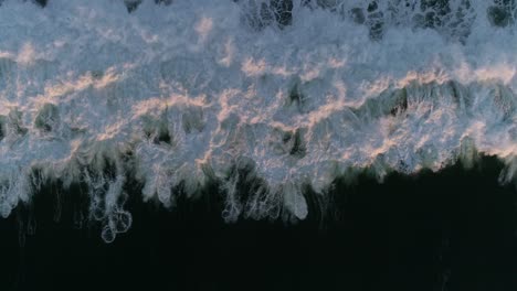 overhead aerial drone of ocean wave on dark sea