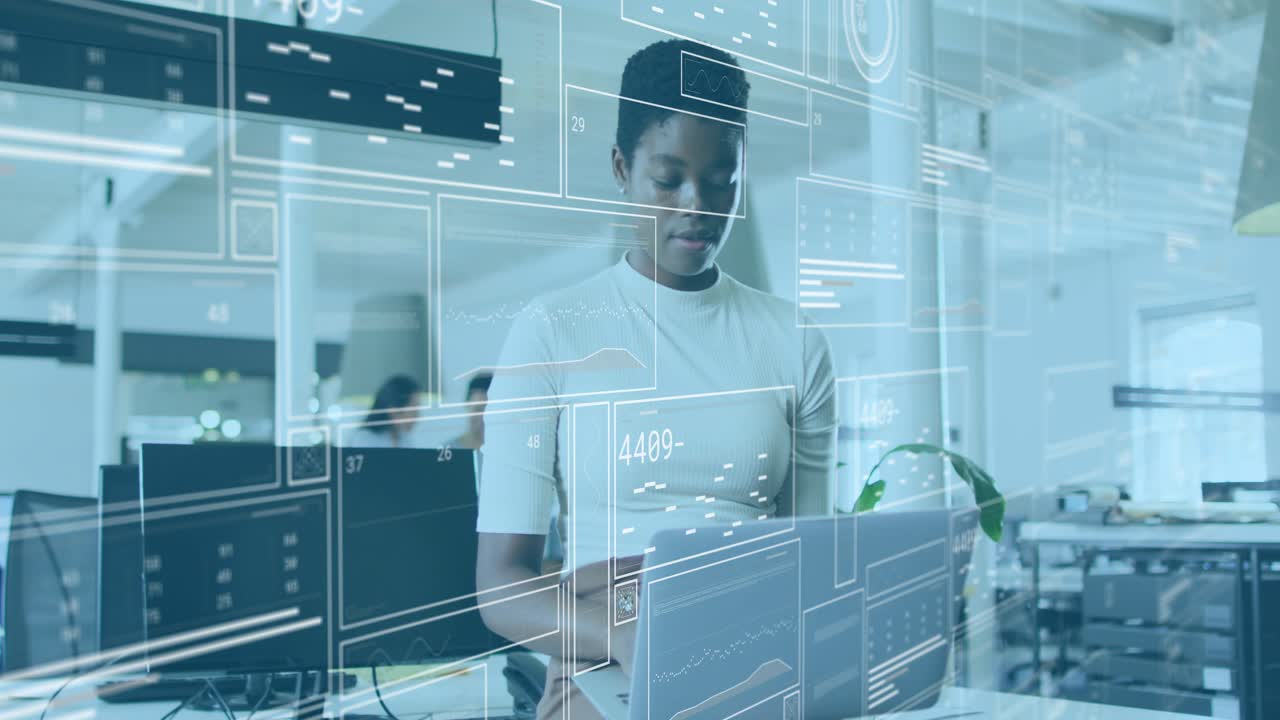 Analyst typing on laptop at standing desk, HUD appearing and driving numeric data monitoring