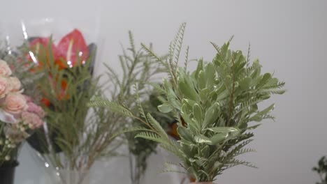 floristería sacudiendo vegetación para ser utilizada en un arreglo de san valentín