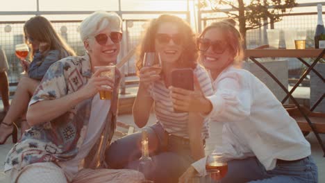 Group-of-caucasian-friends-with-mobile-phone-at-the-party-in-top-of-the-roof.