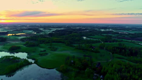 Scenic-Sunset-on-Natural-landscape,-grassland-slopes-with-surrounded-by-water,-Aerial-tracking-shot