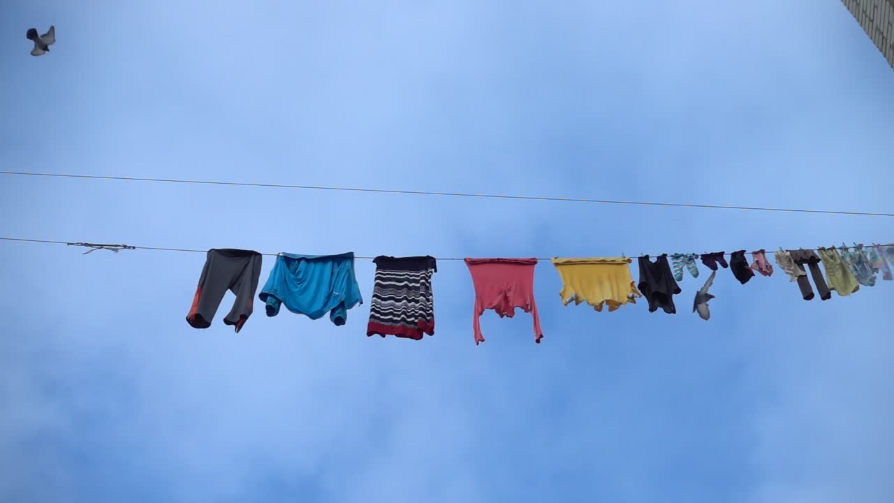 Linen dries highly above the ground on a rope. Slow motion