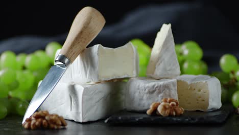 camembert cheese with walnuts and a knife slowly rotate.