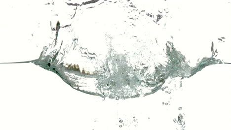 plátano sumergiéndose en el agua sobre un fondo blanco