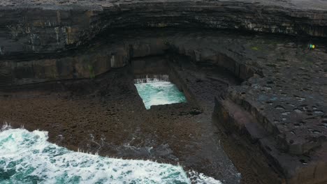 pull away shot of the "wormhole" on the island of inis mór on the west coast of ireland