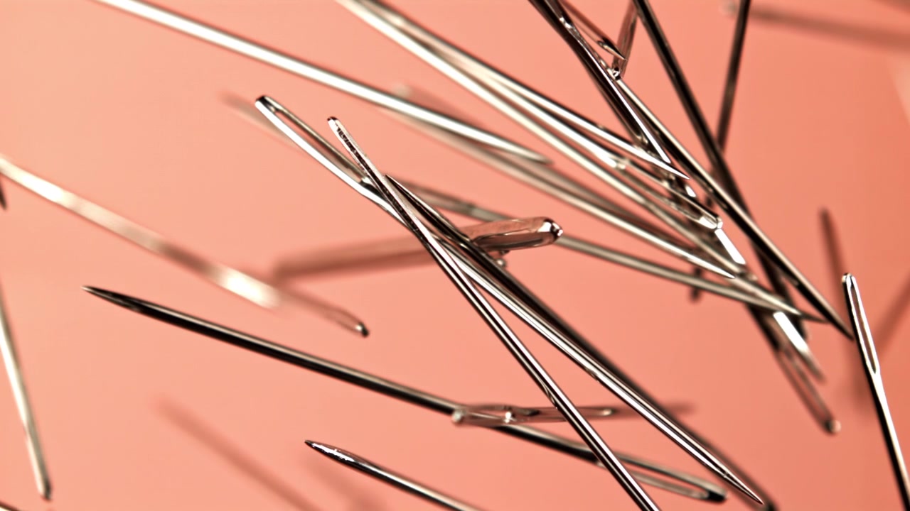 Sharp Sewing Needles Gradually Focusing on a Pink Background