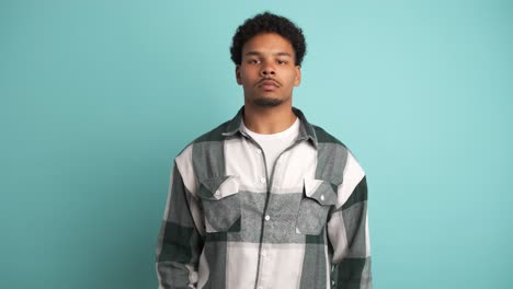 serious young man looking at camera in blue studio