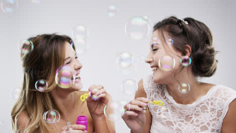 two women blowing bubbles slow motion wedding photo booth series