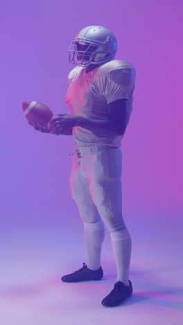 video vertical de un jugador de fútbol americano afroamericano con iluminación púrpura de neón