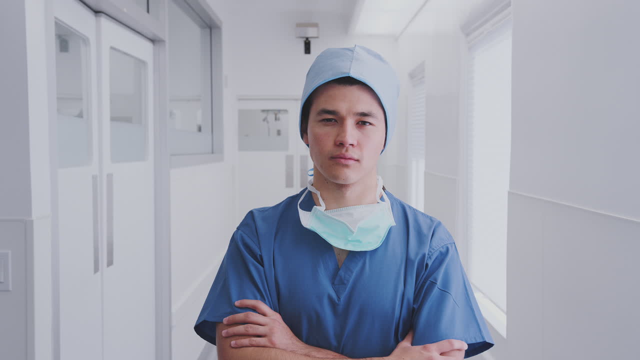 retrato de un cirujano de sexo masculino con exfoliantes y máscara de pie en el pasillo del hospital