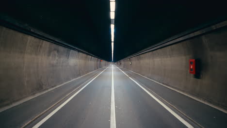 cinematic symmetrical shot of a long endless road inside dark tunnel