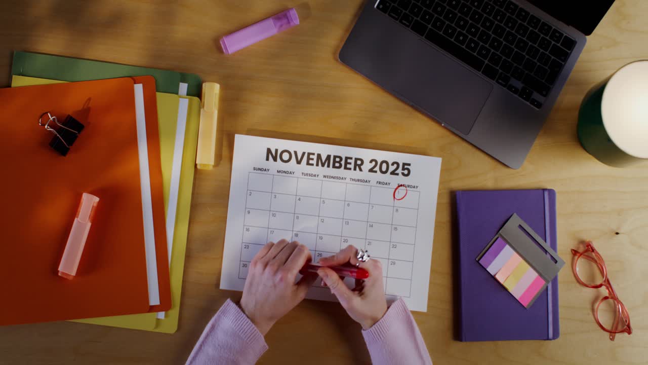 Woman Marking Date on November 2025 Calendar