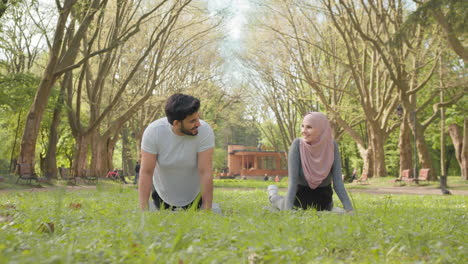 couple practicing yoga in a park