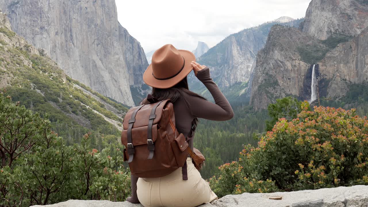 Repullinen nainen nauttimassa Yosemite-laakson ja vesiputouksen upeista näkymistä