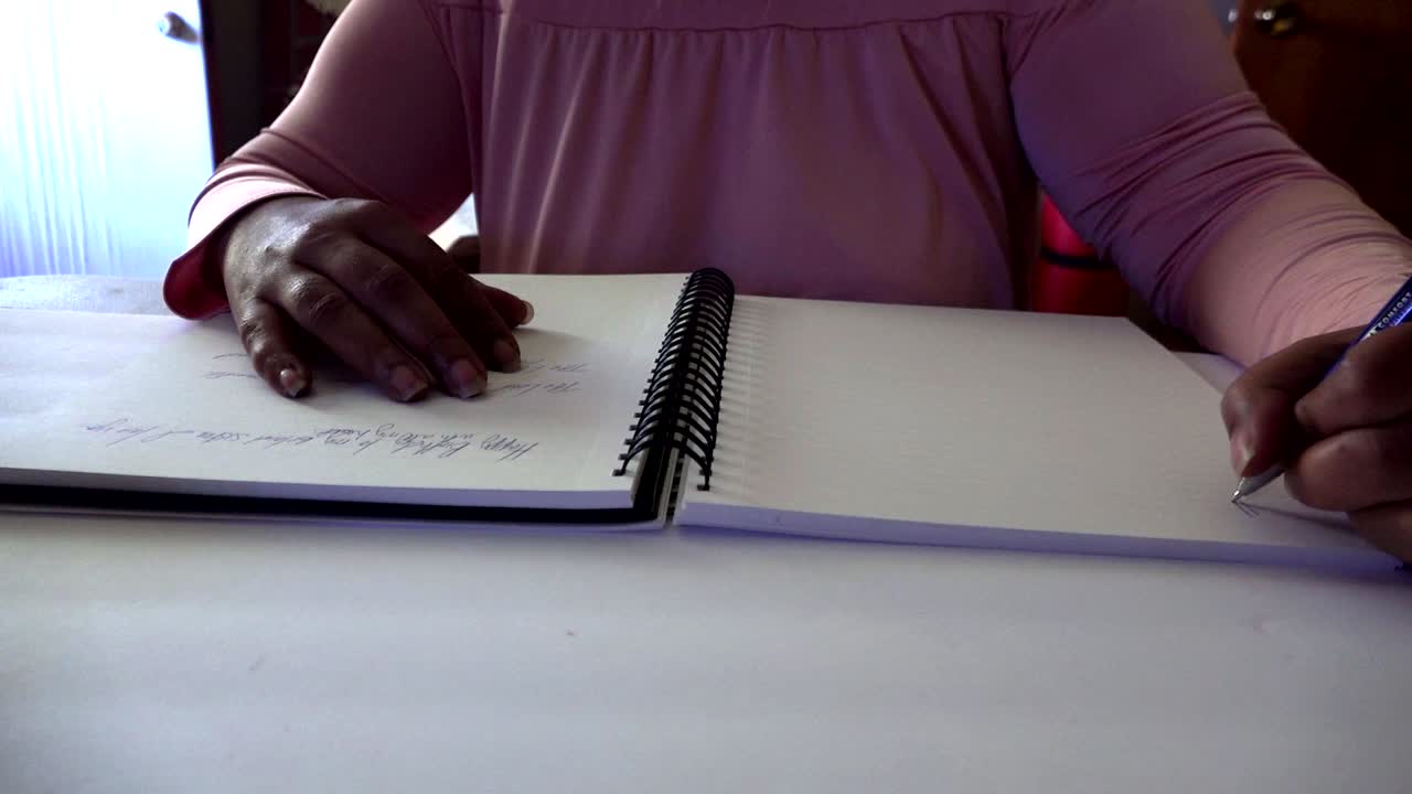 mujer afroamericana escribiendo en un cuaderno