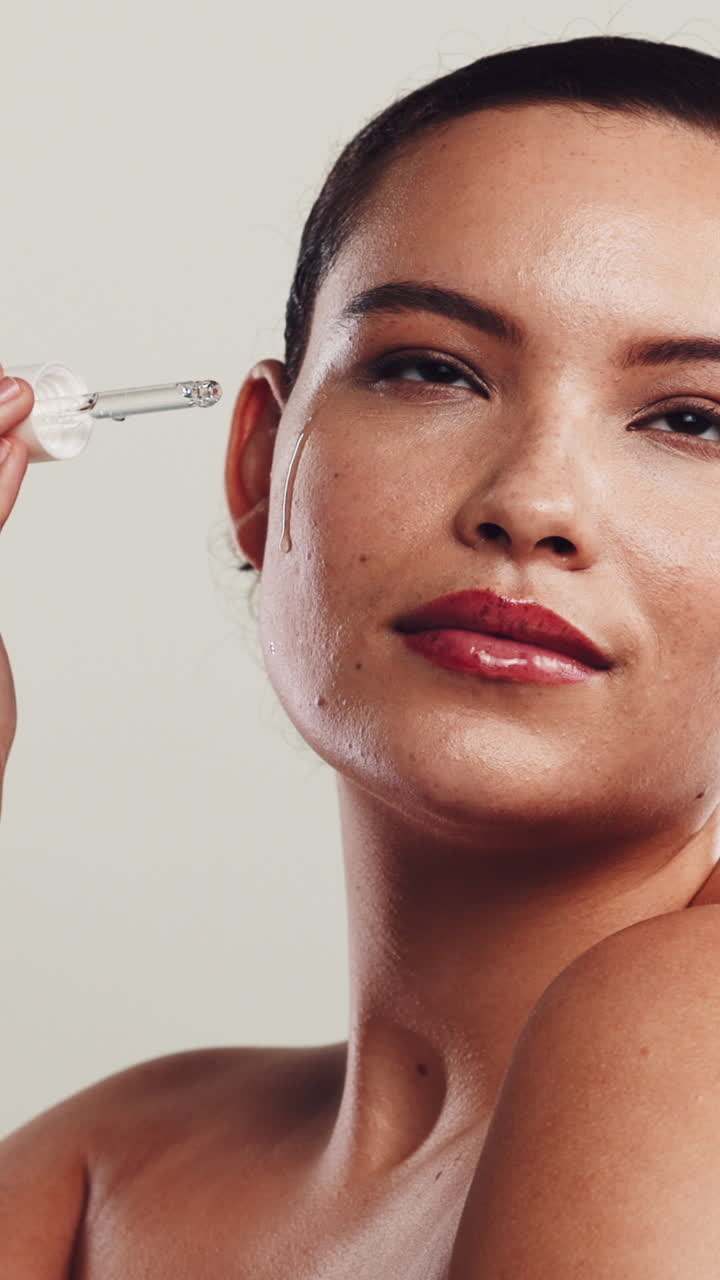 Ung kvinde påfører serum på sit ansigt med en pipette