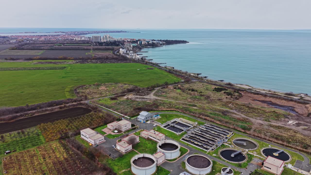 Vista dell'area costiera con edifici, acqua e campi in primo piano