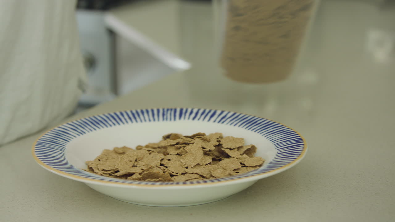 Primo piano in movimento di cereali generici versati in una ciotola.