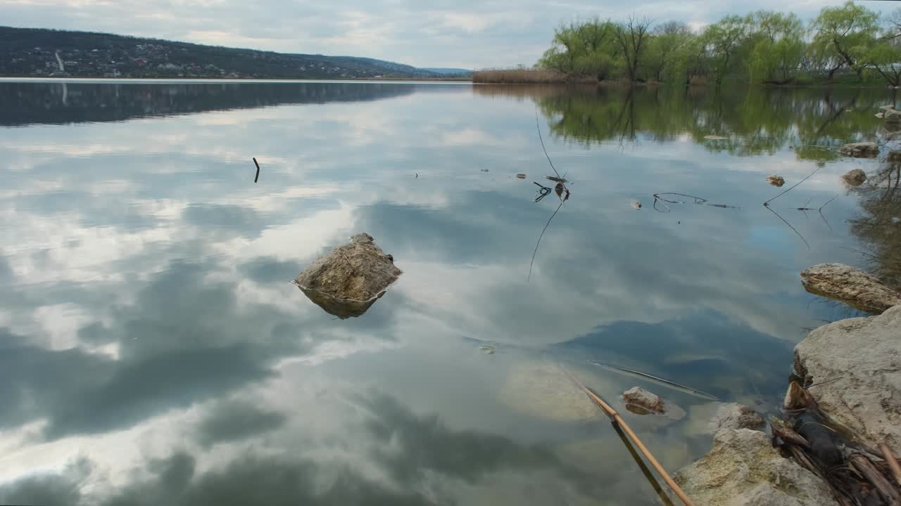 물 속에 구름이 가득한 하늘의 반사와 함께 강이나 호수의 풍경, 저녁이나 아침에 평온한 물의 물결 표면