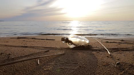 message in the bottle against the sun setting down