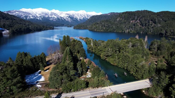 Autostrada che attraversa un fiume forestale e si collega a un vasto lago, vista aerea