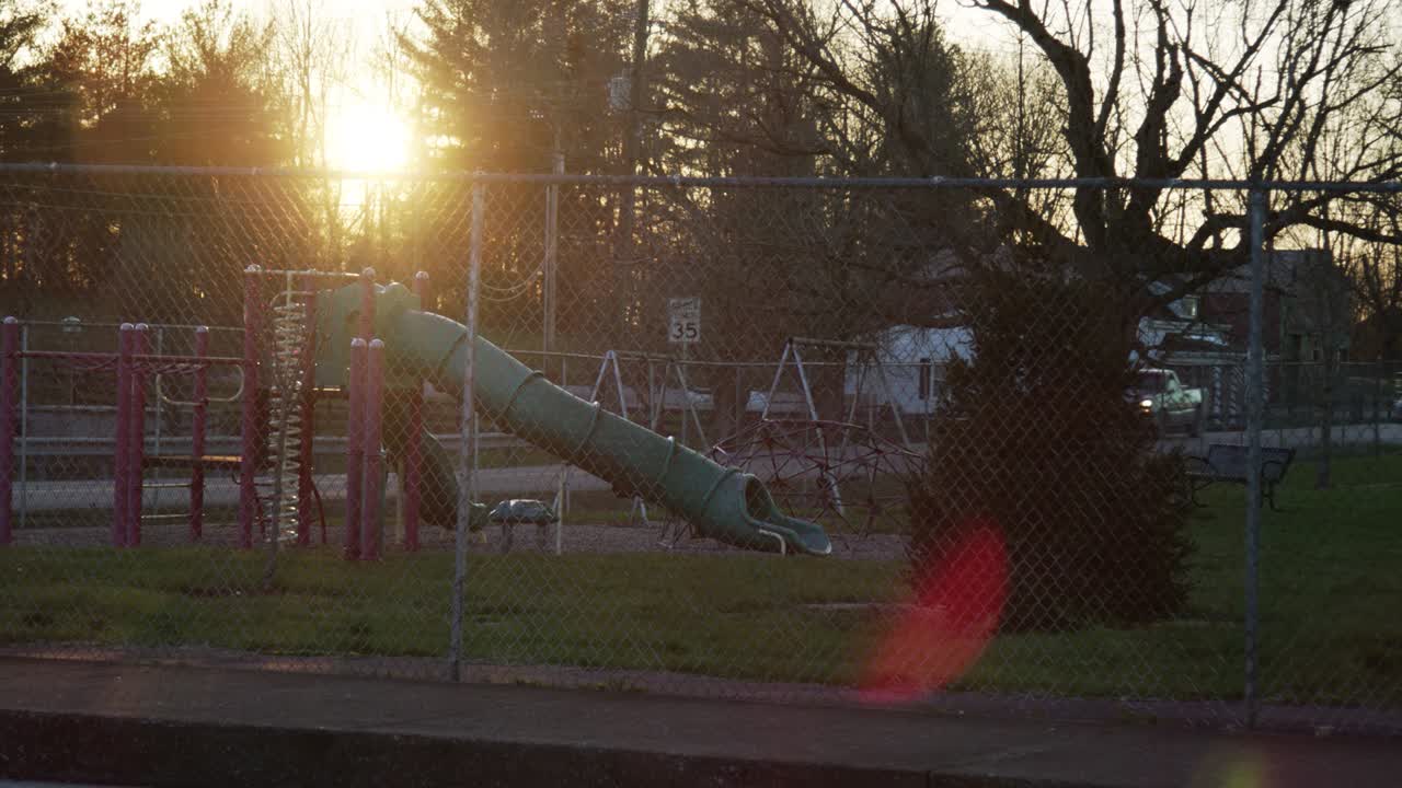 детская площадка через забор на закате