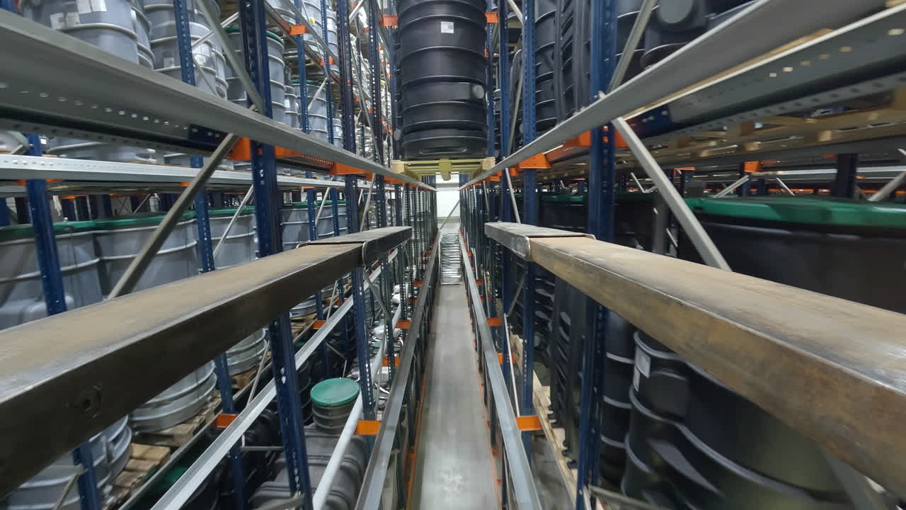 en smal industriell rack, en gaffeltruck beveger seg fremover sakte for nøyaktig å bære en stor plast avløpsvann behandling tank inne