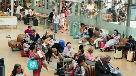 travelers seated and moving in station lounge