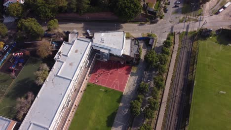 Toma-Aérea-De-Arriba-Hacia-Abajo-Del-Campo-Deportivo-Escolar-En-Buenos-Aires-Durante-El-Día-Soleado,-4k---Campo-De-Fútbol-Y-Baloncesto