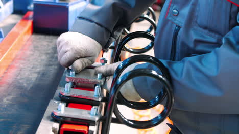 worker tightening screws during assembly process in workshop. manual work