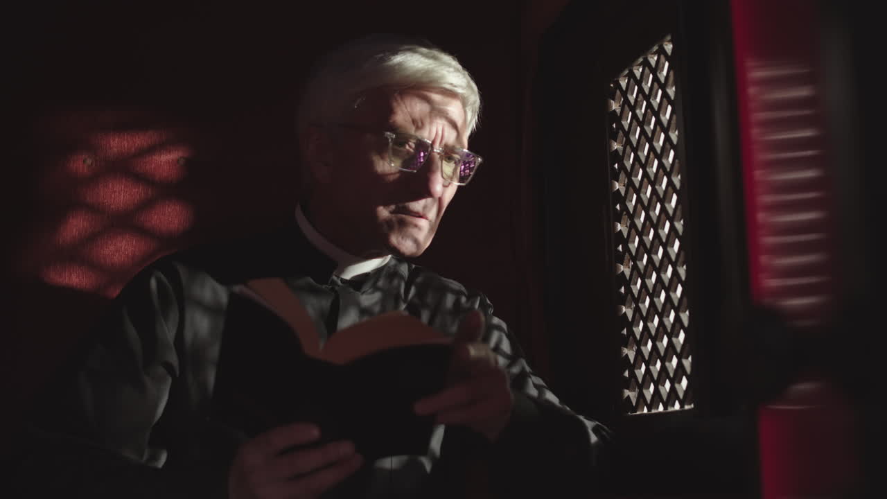 Aged Priest Sitting in Confessional