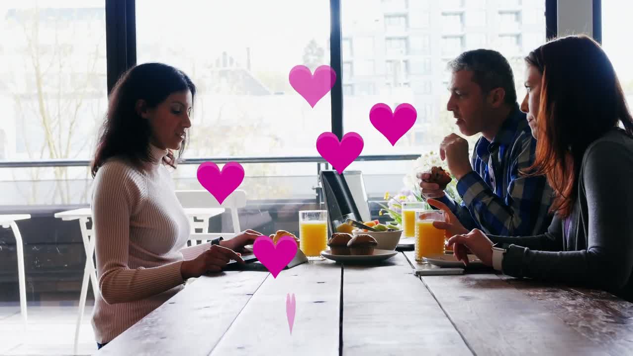 Animation of pink heart icons over diverse business people