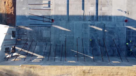 Eine-Drohnenaufnahme-Von-Oben-Nach-Unten-Von-Männern,-Die-Betonplatten-Befestigen