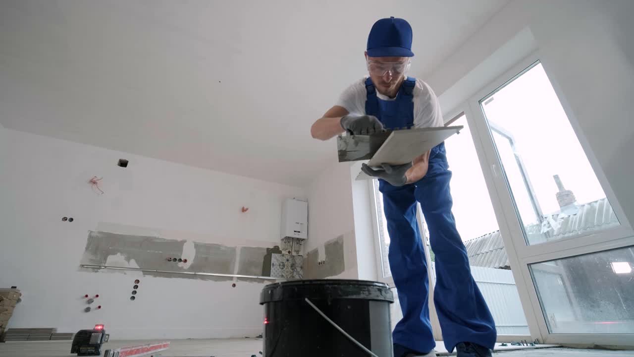 Construction, renovation, repair apartment. Installing ceramic floor tiles - measuring and cutting the pieces. Cuts tile. Tile cutting