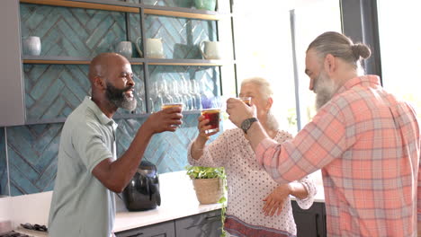 enjoying coffee, senior friends laughing and chatting in modern kitchen