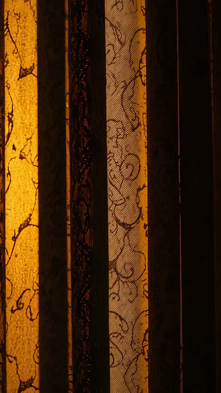 Video verticale: La luce del sole si sposta, accarezzando tende trasparenti e lamelle, una striscia di luce si muove verso l'interno mostrando pizzi