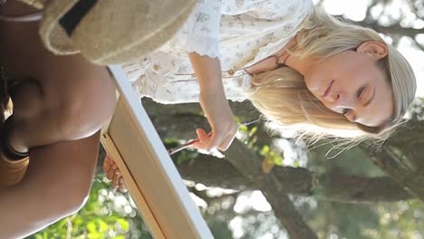 blonde woman painting outdoors