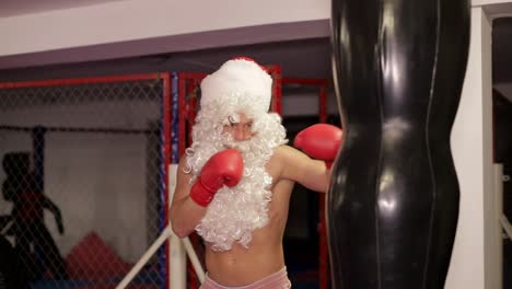 santa claus beats boxing bag angry santa claus santa claus kickboxer training in the gym the concept of sport