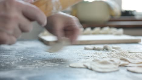 making meat dumpling with wooden rolling pin.