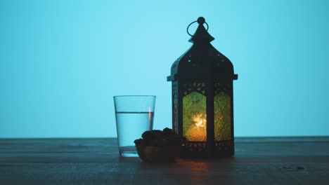 tracking shot of lantern water and dates on a table during dusk ramadan celebrations