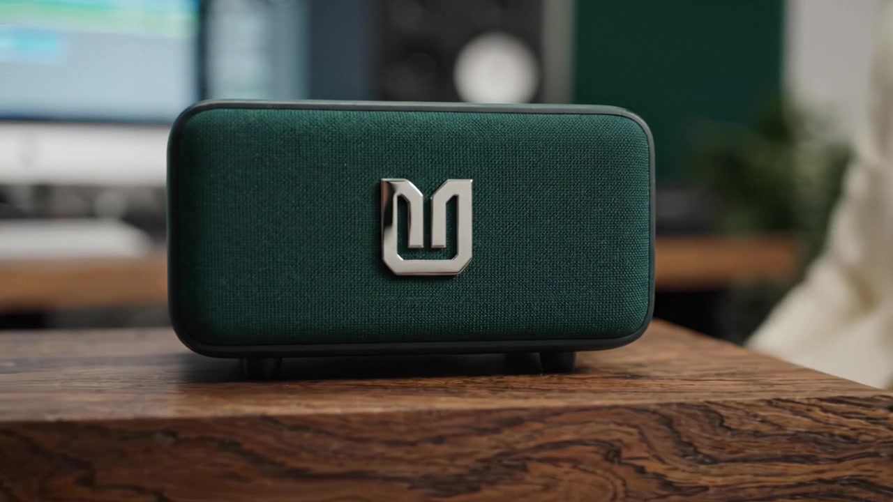 Un'ingegnera del suono concentrata che lavora in uno studio moderno, mostrando attrezzature per la produzione musicale mentre è seduta a una scrivania elegante con componenti di un sistema audio