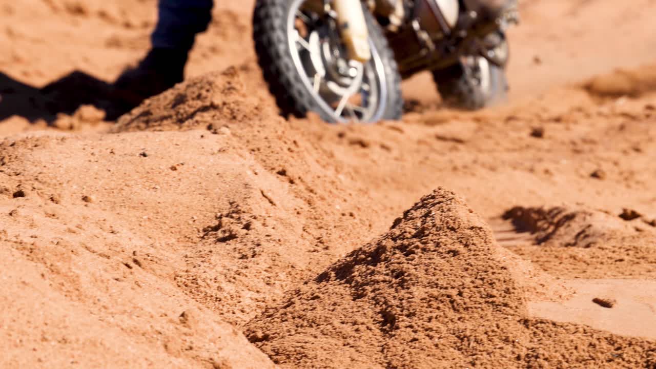 도전적 인 모래 지형 을 가로질러 이동 하는 더트 자전거