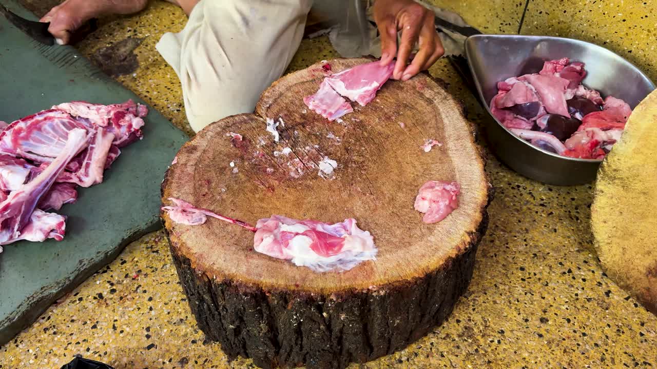Scena di taglio manuale della carne con attrezzi da macellaio e parti di animali fresche sul tagliere