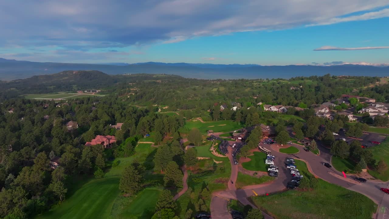 The Ridge North Castle Pines Village Golf Course aerial drone Colorado summer spring golfing Rocky Mountains front range parking lot green grass fairway sand traps morning blue sky forward pan