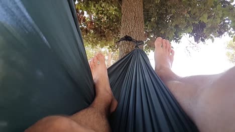 slowmotion of happy youngster enjoying the day and swinging left and right in the hammock