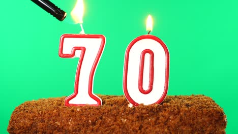 cake with the number 70 lighted candle. chroma key. green screen. isolated
