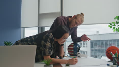 multiracial colleagues discussing blueprint at office. architect team analyzing