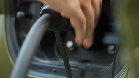extreme close up of person opening vehicle inlet port of zero emissions ev car